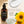 Francis Michael Hydrating Lotion in an amber pump bottle, shown beside a close-up of white lotion cream and a glass bowl of clear gel, with text reading 'What it does' and sunflower graphics on a warm beige background.