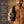 A shirtless man holds a brown pump bottle of Francis Michael Hydrating Lotion against a warm brown background, with text on the left explaining product ingredients and benefits.