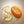 Yellow gel-like substance in a curved shape of Francis Michael Revitalizing Oil next to a round, orange-colored Francis Michael Nourishing Serum on a neutral background