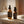 Two bottles of Francis Michael skincare products, Revitalizing Oil and Nourishing Serum, on a stone surface with a blurred background.