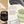 Francis Michael Purifies Detoxifying Mask jar shown on a beige promotional graphic with product benefits text, a black mask smear, white clay, and green powder.